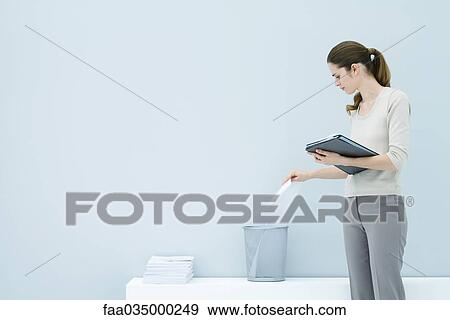 Stock Photo - Professional woman throwing away document, holding folder. Fotosearch
