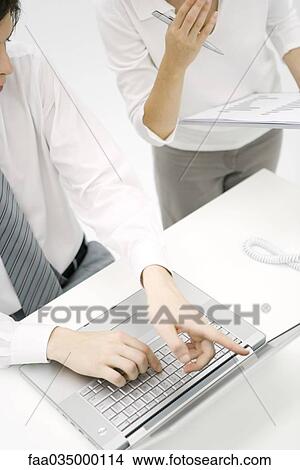 Professionals looking at laptop computer together, cropped high angle view View Large Photo Image Picture - Professionals looking at laptop computer together, cropped high angle view. Fotosearch