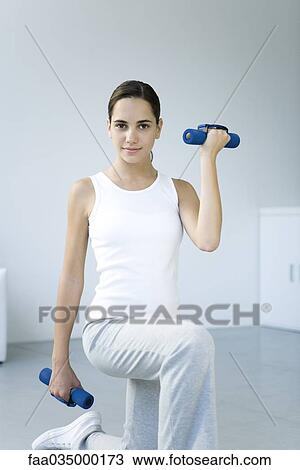 Teenage girl doing lunges with dumbbells, smiling at camera View Large Photo Image Stock Image - Teenage girl doing lunges with dumbbells, smiling at camera. Fotosearch