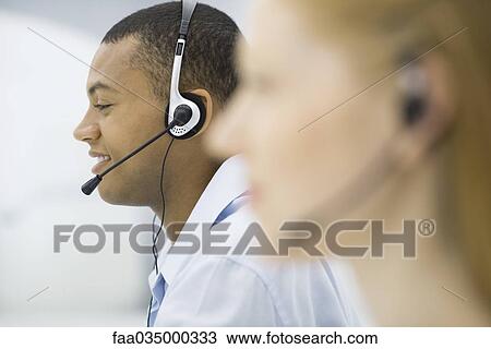 Telemarketers wearing headsets, profile, focus on background View Large Photo Image Stock Image - Telemarketers wearing headsets, profile, focus on background. Fotosearch