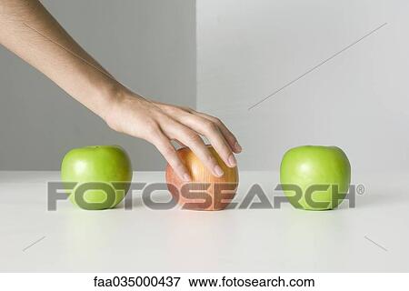 Three apples, hand selecting red apple View Large Photo Image Stock Photo - Three apples, hand selecting red apple. Fotosearch
