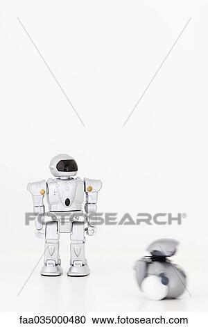 Stock Image - Toy robots, one in motion. Fotosearch