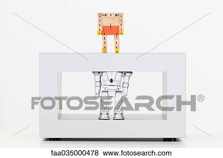 Toy robots standing on coffee table, the one above looking down at the one below View Large Photo Image Stock Photo - Toy robots standing on coffee table, the one above looking down at the one below. Fotosearch