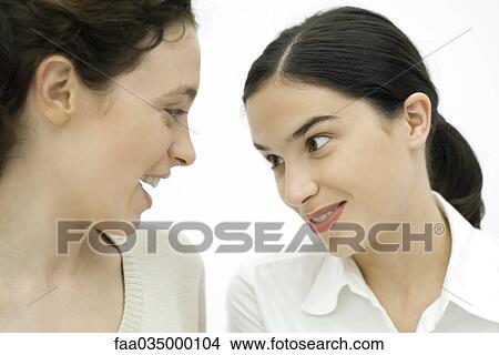 Two young women face to face, smiling, close-up View Large Photo Image Picture - Two young women face to face, smiling, close-up. Fotosearch