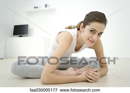 Woman doing butterfly stretch, smiling at camera View Large Photo Image Stock Photo - Woman doing butterfly stretch, smiling at camera. Fotosearch