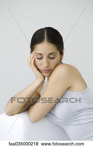 Stock Photo - Woman leaning on elbow, looking down. Fotosearch