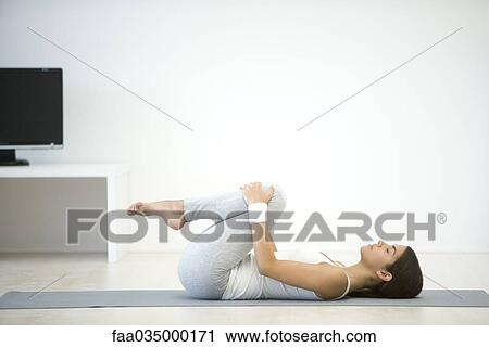 Woman lying on back, pulling knees up toward chest View Large Photo Image Stock Image - Woman lying on back, pulling knees up toward chest. Fotosearch