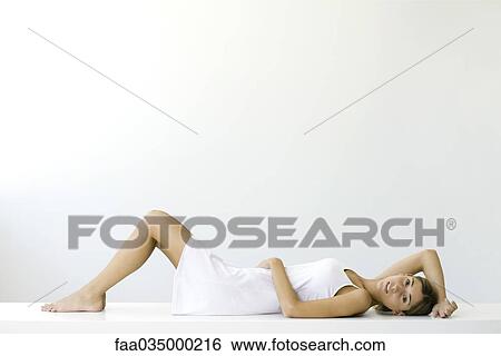 Woman lying on back, smiling at camera View Large Photo Image Stock Photograph - Woman lying on back, smiling at camera. Fotosearch