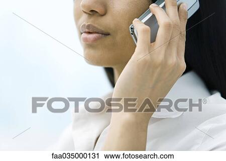 Stock Image - Woman using cell phone, cropped view. Fotosearch