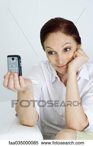 Woman using cell phone to photograph herself View Large Photo Image Stock Photography - Woman using cell phone to photograph herself. Fotosearch