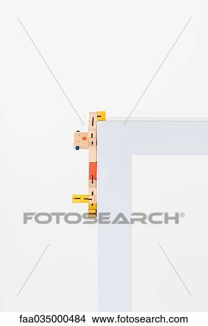 Wooden toy hanging on to edge of table View Large Photo Image Picture - Wooden toy hanging on to edge of table. Fotosearch