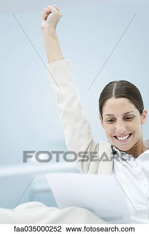 Young businesswoman reading document, raising one arm in the air View Large Photo Image Stock Image - Young businesswoman reading document, raising one arm in the air. Fotosearch