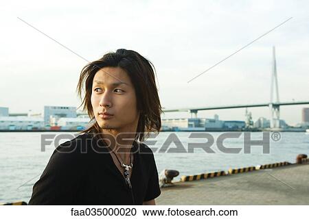Young Japanese man standing by Tempozan Harbour, Osaka, Japan View Large Photo Image Stock Image - Young Japanese man standing by Tempozan Harbour, Osaka, Japan. Fotosearch