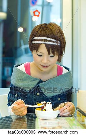 Young Japanese woman eating ice cream sundae View Large Photo Image Stock Image - Young Japanese woman eating ice cream sundae. Fotosearch