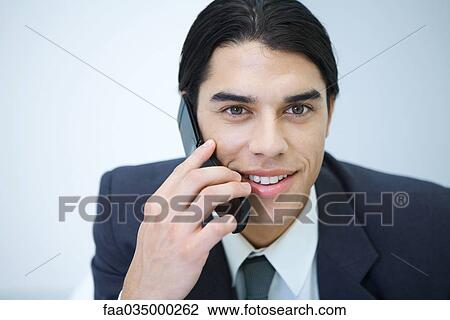 Young professional man holding cell phone, smiling, portrait View Large Photo Image Stock Image - Young professional man holding cell phone, smiling, portrait. Fotosearch