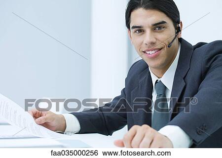 Young professional man wearing headset, smiling at camera, portrait View Large Photo Image Stock Photograph - Young professional man wearing headset, smiling at camera, portrait. Fotosearch