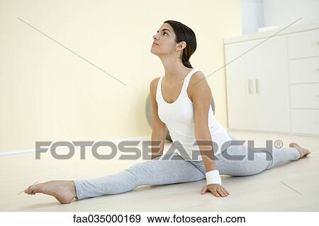 Young woman doing splits, looking up View Large Photo Image Stock Photo - Young woman doing splits, looking up. Fotosearch