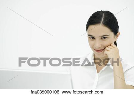 Stock Photograph - Young woman leaning on elbow, smiling at camera. Fotosearch