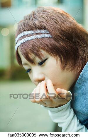 Young woman resting chin on hand, looking down View Large Photo Image Stock Photography - Young woman resting chin on hand, looking down. Fotosearch