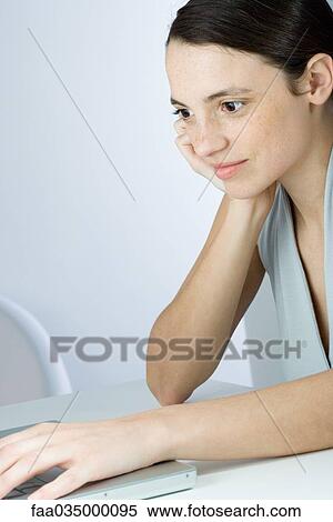Young woman staring at laptop computer, cropped view View Large Photo Image Stock Photography - Young woman staring at laptop computer, cropped view. Fotosearch