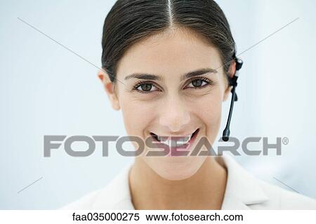 Young woman wearing headset, smiling at camera, portrait View Large Photo Image Stock Photography - Young woman wearing headset, smiling at camera, portrait. Fotosearch