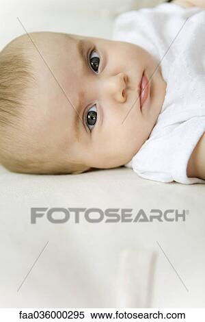 Baby lying on back, looking at camera, close-up View Large Photo Image Stock Photography - Baby lying on back, looking at camera, close-up. Fotosearch
