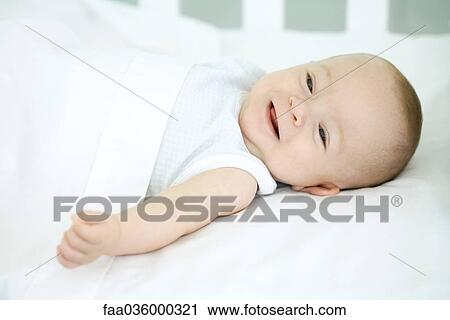 Baby lying on back, smiling, close-up View Large Photo Image Stock Image - Baby lying on back, smiling, close-up. Fotosearch