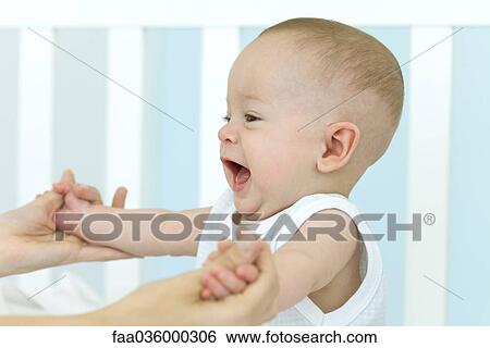 Stock Photograph - Baby playing with mother, cropped view. Fotosearch