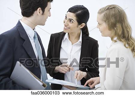 Business associates looking at document together View Large Photo Image Stock Image - Business associates looking at document together. Fotosearch