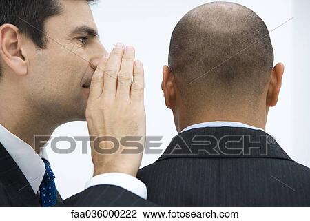 Businessman whispering in colleague's ear, close-up View Large Photo Image Stock Image - Businessman whispering in colleague's ear, close-up. Fotosearch