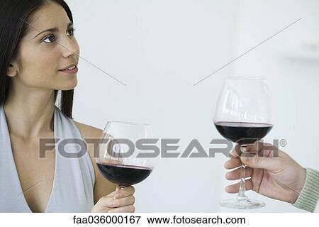 Couple holding glasses of red wine, cropped view View Large Photo Image Stock Photo - Couple holding glasses of red wine, cropped view. Fotosearch