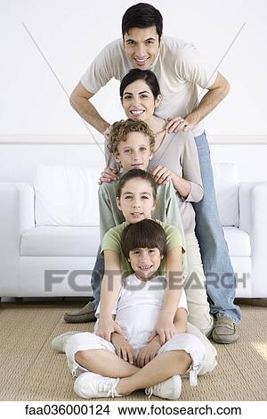 Picture - Family lined up one behind the another, shortest to tallest, posing for group photo. Fotosearch