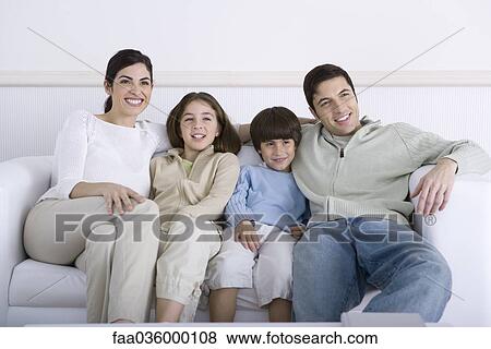 Family sitting together on sofa, looking away View Large Photo Image Stock Photo - Family sitting together on sofa, looking away. Fotosearch