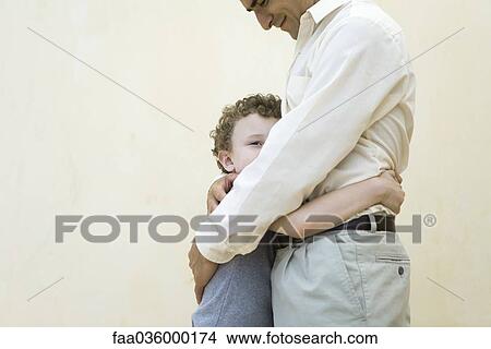 Picture - Father and son embracing, side view, cropped. Fotosearch