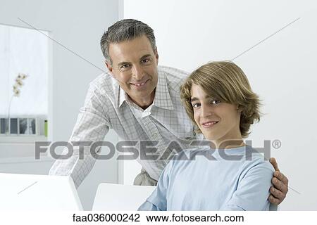 Father and son smiling at camera, man's arm around teenager's shoulder View Large Photo Image Stock Image - Father and son smiling at camera, man's arm around teenager's shoulder. Fotosearch