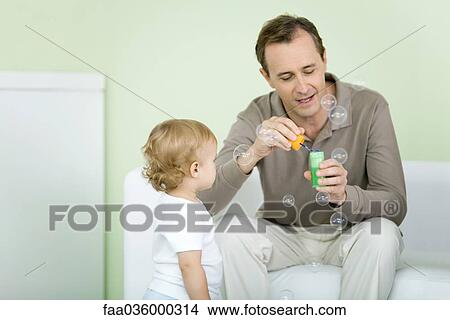 Father and toddler blowing bubbles together View Large Photo Image Picture - Father and toddler blowing bubbles together. Fotosearch
