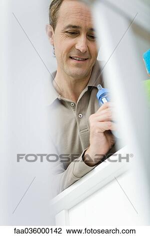 Father leaning against crib, holding baby bottle, looking down, low angle view View Large Photo Image Stock Image - Father leaning against crib, holding baby bottle, looking down, low angle view. Fotosearch
