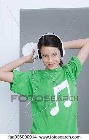 Picture - Girl listening to portable CD player, wearing tee-shirt with musical note printed on it. Fotosearch