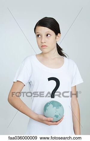 Girl wearing tee-shirt printed with question mark, holding globe, looking away View Large Photo Image Stock Photo - Girl wearing tee-shirt printed with question mark, holding globe, looking away. Fotosearch