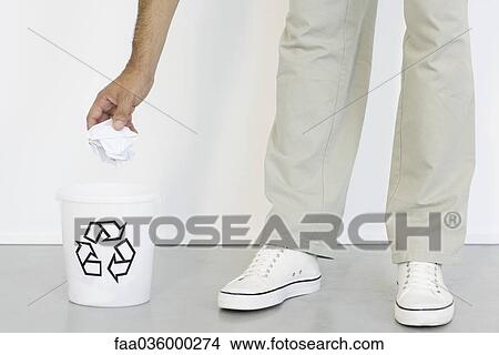Hand placing crumpled paper into recycle bin, close-up View Large Photo Image Picture - Hand placing crumpled paper into recycle bin, close-up. Fotosearch