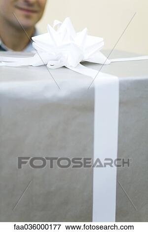 Man carrying large present, close-up View Large Photo Image Stock Photo - Man carrying large present, close-up. Fotosearch