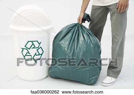 Man holding large garbage bag next to recycling bin, cropped view View Large Photo Image Stock Image - Man holding large garbage bag next to recycling bin, cropped view. Fotosearch