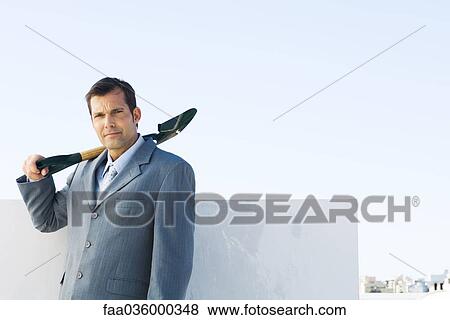 Man in suit holding shovel, looking at camera View Large Photo Image Stock Photo - Man in suit holding shovel, looking at camera. Fotosearch