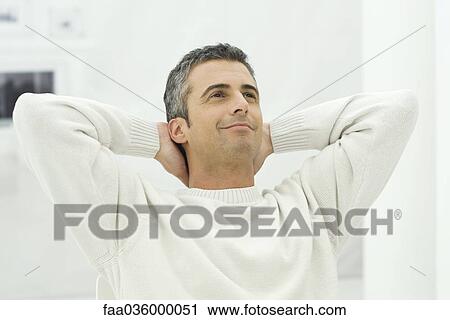 Man leaning back with hands behind head, smiling View Large Photo Image Stock Image - Man leaning back with hands behind head, smiling. Fotosearch