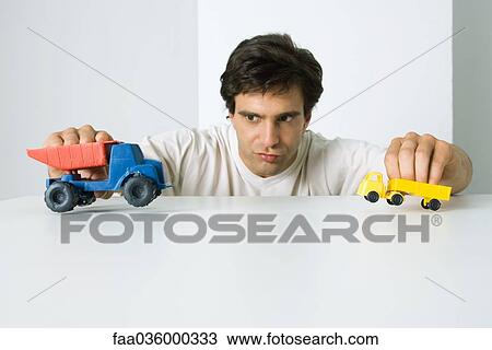 Man playing with toy trucks View Large Photo Image Stock Image - Man playing with toy trucks. Fotosearch