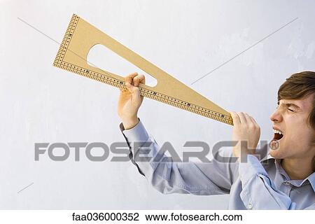 Man pretending triangular measuring instrument is a megaphone, shouting with eyes closed View Large Photo Image Stock Image - Man pretending triangular measuring instrument is a megaphone, shouting with eyes closed. Fotosearch