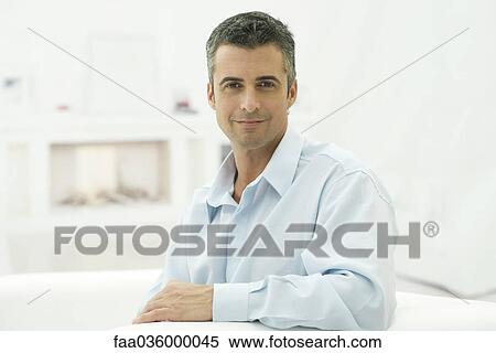 Man sitting, smiling at camera, portrait View Large Photo Image Stock Photography - Man sitting, smiling at camera, portrait. Fotosearch
