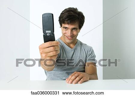 Stock Image - Man taking photograph with self with cell phone. Fotosearch