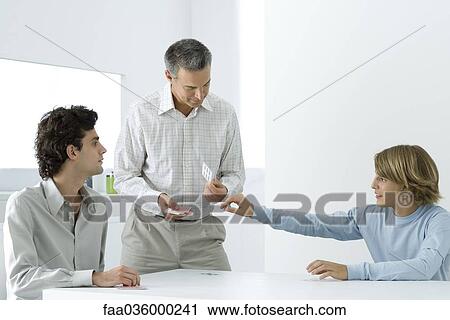Mature father and two sons playing cards View Large Photo Image Stock Image - Mature father and two sons playing cards. Fotosearch