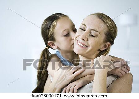 Mother and daughter embracing, girl kissing woman's cheek View Large Photo Image Stock Image - Mother and daughter embracing, girl kissing woman's cheek. Fotosearch